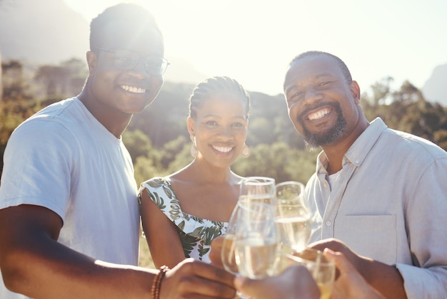 Wijnglazen champagne en vrienden portret in een park wijngaard of groene natuur viering voor zomervakantie Gelukkig vriendschap en alcohol met zwarte mensen en vrouw glimlach drankje en lens flare