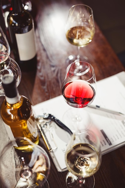 Wijnglazen en wijnflessen rond klembord op tafel