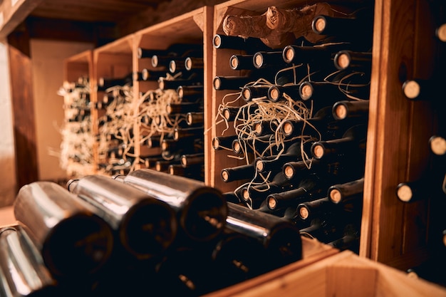 Wijnkelder met flessen alcoholische drank in houten kisten en wijnrekken