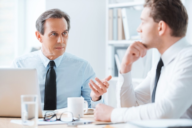 Wijs advies voor zaken leuk. Twee zakenmensen in formalwear die iets bespreken