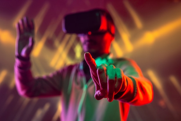 Wijsvinger van jonge man met vr-headset op virtuele knop te drukken of display aan te raken tijdens het reizen in augmented reality