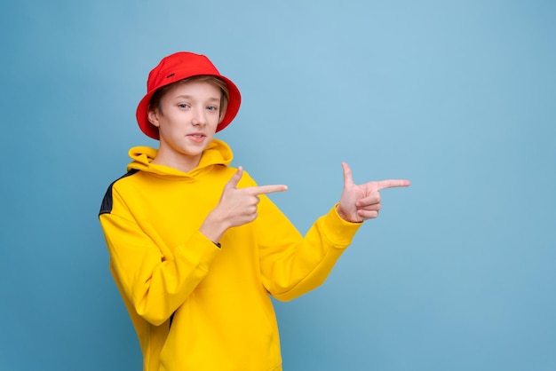 Wijzend gebaar naar de andere kant met je vinger rapper informatie banner stijlvolle hipster man in gele sw...