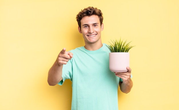 Wijzend op de camera met een tevreden, zelfverzekerde, vriendelijke glimlach, jou kiezen. decoratief plantenconcept