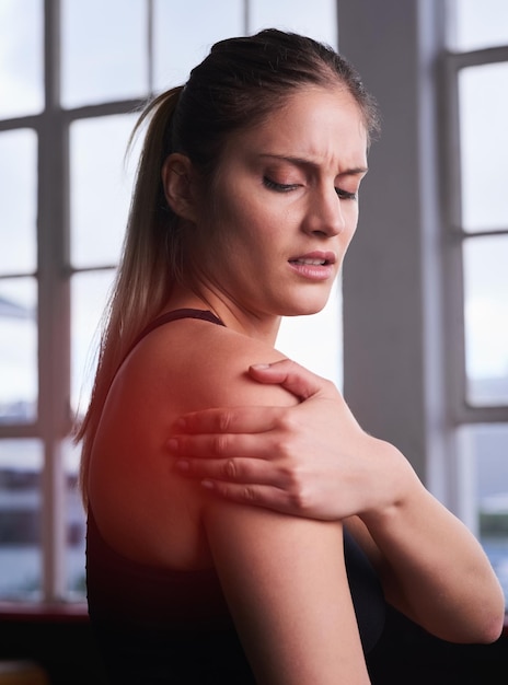 Wil je weten waarom stretchen belangrijk is shot van een sportieve jonge vrouw die haar geblesseerde schouder vasthoudt die rood is gemarkeerd