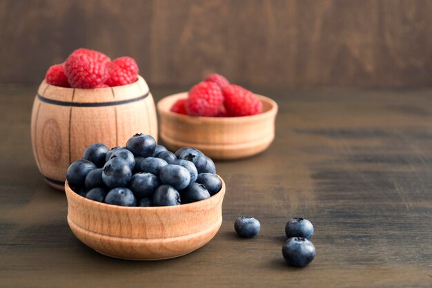 Wild berries, raspberries and blueberries on a brown background.