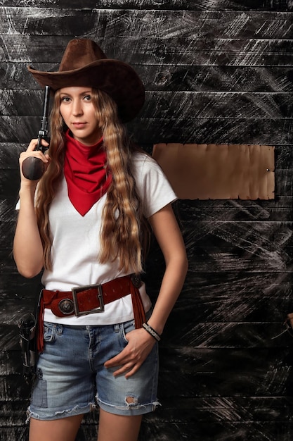 Фото Дикая ковбойская девушка с пистолетом вблизи с копировальным пространством