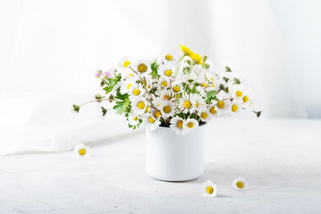 白いテーブルの上の野生のデイジーの花