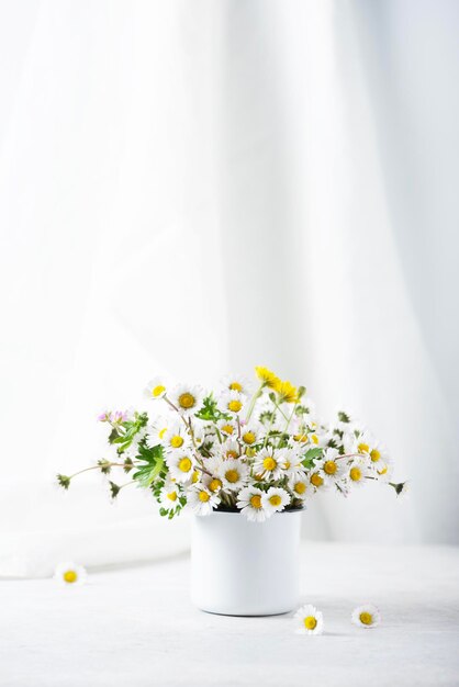 白いテーブルの上の野生のデイジーの花