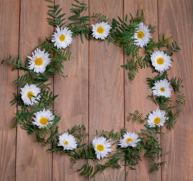 Wild field plants over brown wooden table