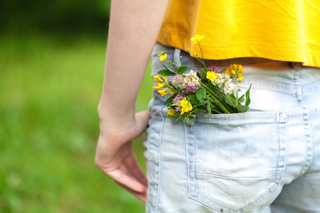 ブルージーンズのポケットの中の野生の花