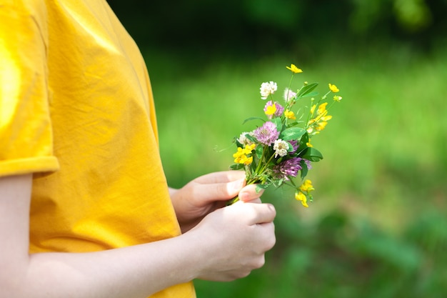 女性の手の中の野生の花