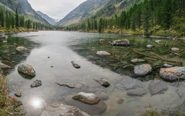 Wild mountain lake on a gloomy morning rocky bottom