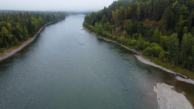 Wild nature landscape drone view with river and forest. Mountain Siberian river flow, water on stone