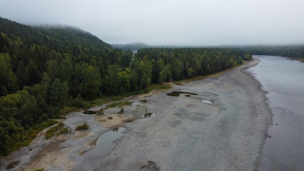 川と森のある野生の自然の風景ドローン ビュー。山シベリア川の流れ、石の上の水