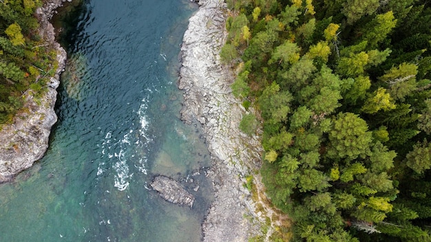 Wild nature landscape drone view with river and forest. Mountain Siberian river flow, water on stone