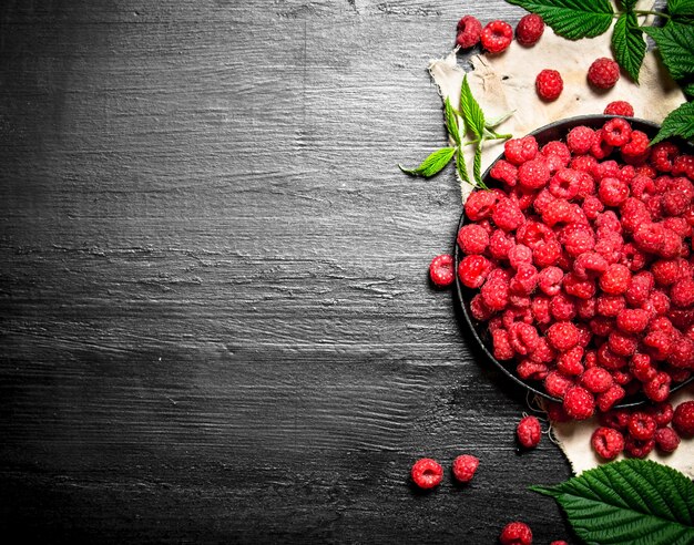 Wild raspberry with leaves on the old plate.