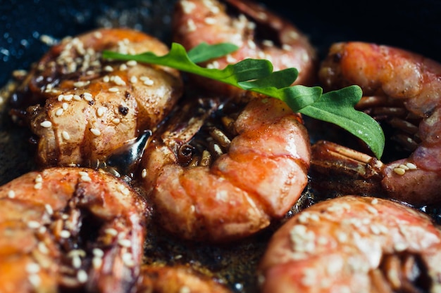 Wild red Argentine shrimp fried in the pan in butter with garlic and sesame seeds top view