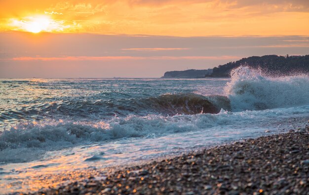 The wild waves on the beach at sunset