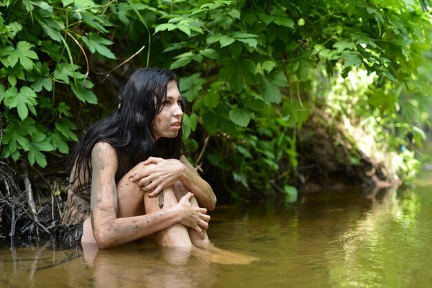 Wild young woman in black clothing posing in river