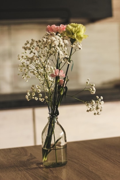 Wilde bloemen in een transparante vaas in het interieur