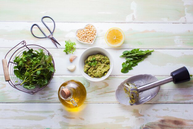 Wilde kruiden pesto ingrediënten op witte houten achtergrond bovenaanzicht