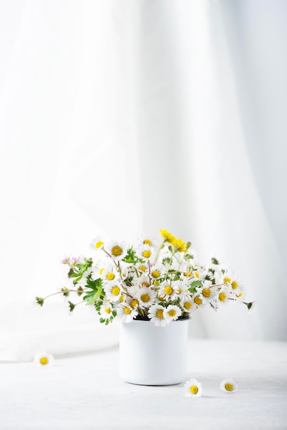 Wilde madeliefjebloemen op de witte tafel