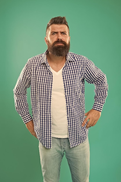 Останется ли борода в моде Брутальный хипстер с бородой на голубом фоне Бородатый мужчина в повседневном стиле Стрижка бороды Парикмахерская с бородой Парикмахерская Мода и стиль