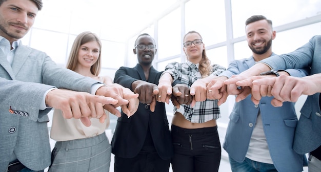 Photo will you join our teamgroup of cheerful young people standing close to each other and pointing you