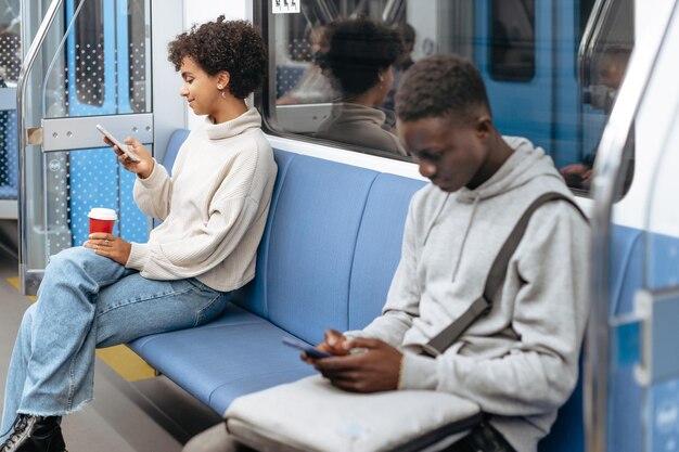 Foto willekeurige metropassagiers die hun smartphones gebruiken terwijl ze zitten i