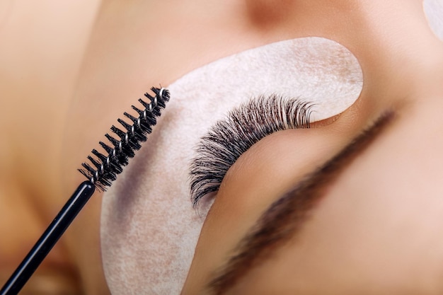 Wimperverlenging procedure vrouw oog met lange blauwe wimpers ombre effect close-up selectieve focus