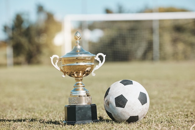 Photo win field and football and trophy for sports game award and achievement in a contest fitness grass and a prize or reward for soccer competition championship or celebration of a goal at a stadium