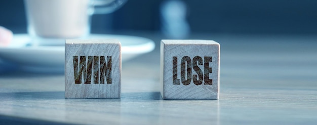 Photo win and lose on wooden cubes and cacao cup business success and failure concept