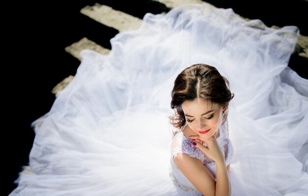 Il vento soffia il vestito della sposa mentre lei sta sulle orme rovinate