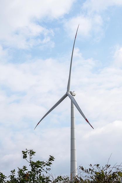 Wind generator turbine against blue cloudy sky