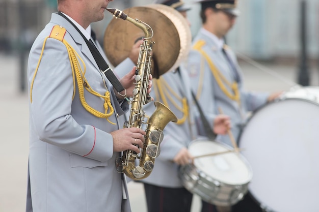 管楽器がサックスを演奏する男性をパレードする