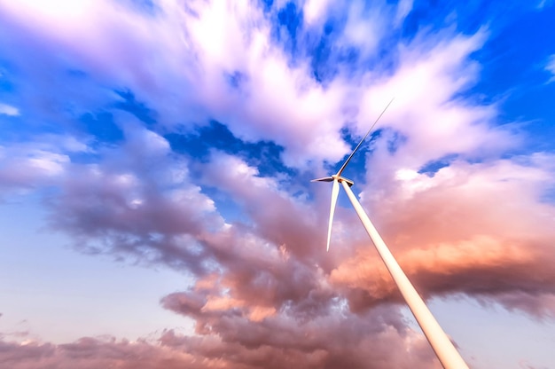 Wind turbine in action against a cloudy blue sky