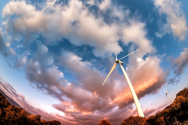 写真 劇的な曇りの夕方の空を背景にした風力タービン