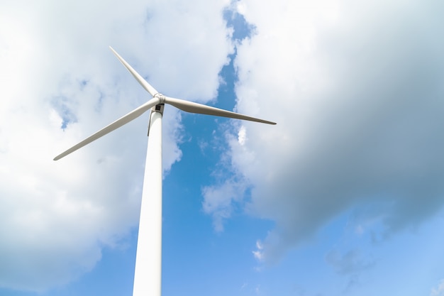 Wind turbine against a cloudy blue sky