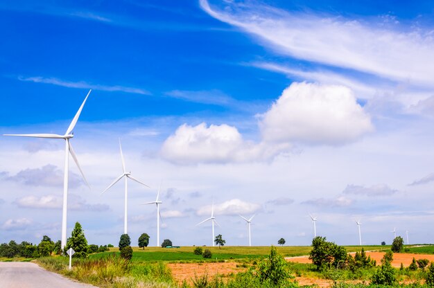 Wind turbine on the green meadow over the blue sky