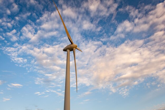 Turbina eolica all'aperto con la conservazione del sole e del cielo blu e il concetto di energia sostenibile