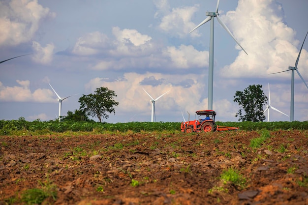 Ветряная турбина на тракторной коричневой траве над горой голубое небо