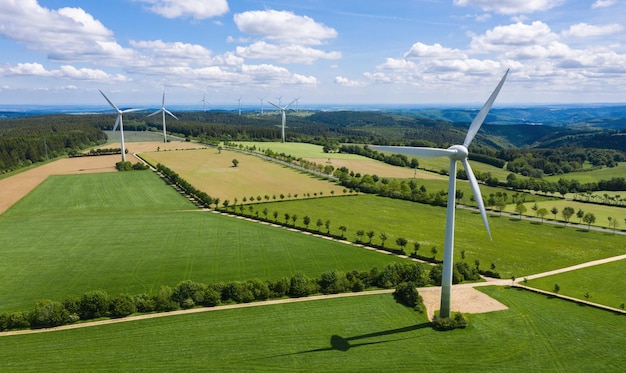 Wind turbines and agricultural fields on a summer day - Energy Production with clean and Renewable Energy - aerial shot