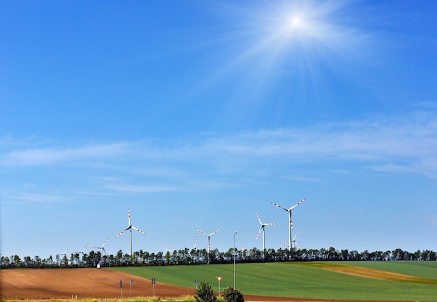 Wind turbines on blue sunshiny sky background