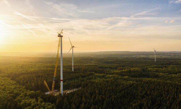 Wind turbines under construction in the forest - Energy Production with clean and Renewable Energy - aerial shot