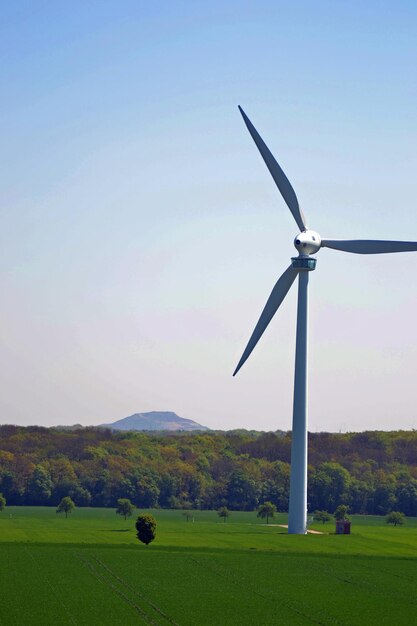 Wind turbines on field against sky