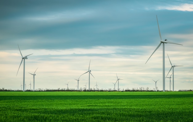 Photo wind turbines generating electricity with cloudy sky energy conservation concept