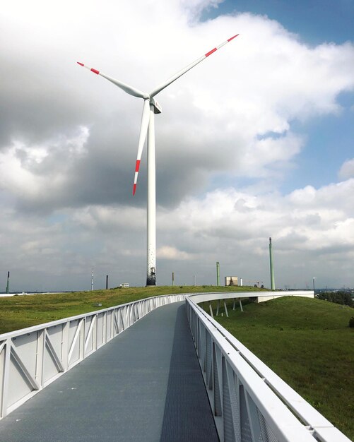 Wind turbines on landscape against sky