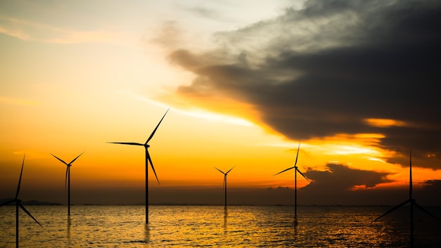 Wind turbines in the ocean at sunset