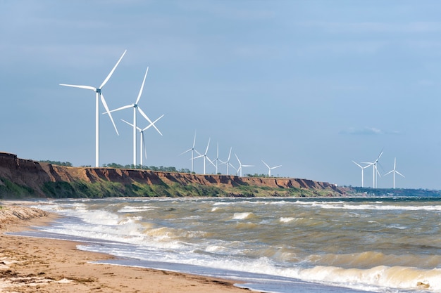 Wind wheels on sea coast against the sky