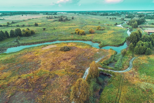 The winding brook flows across the field view from above